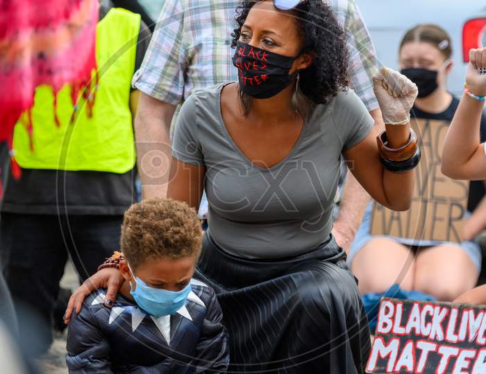 Powerful Bame Woman Wears Black Lives Matter Ppe Face Mask And Salutes While Holding Her Son At Blm Protest