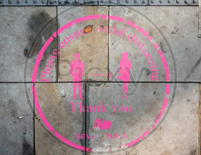 London - November 3, 2020: An Overhead Shot Of A Pink Covid 19 Social Distancing Sign Painted On The Ground In Covent Garden
