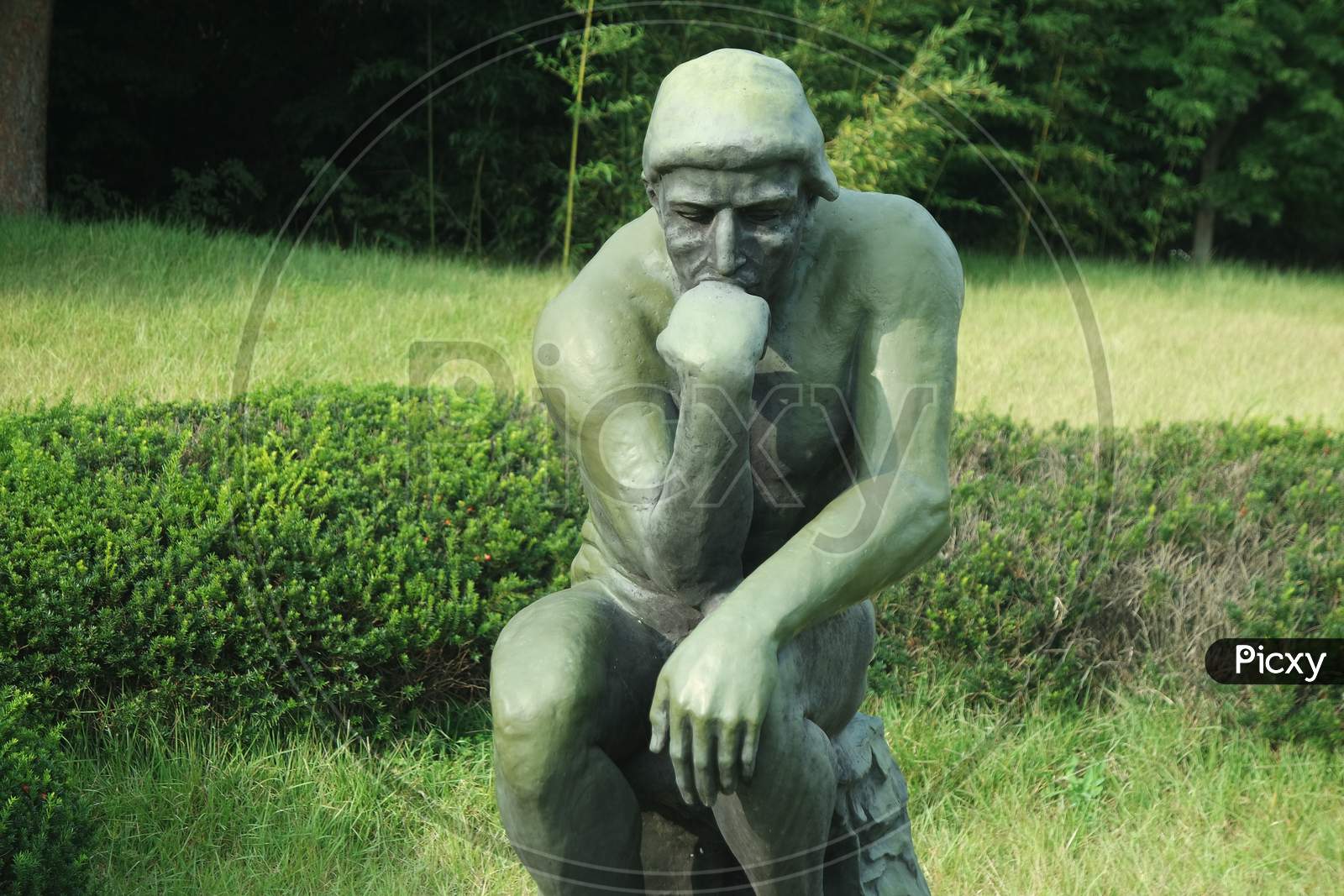 Green Statue Of Thinker Auguste Rodin, Setting Naked On A Rock