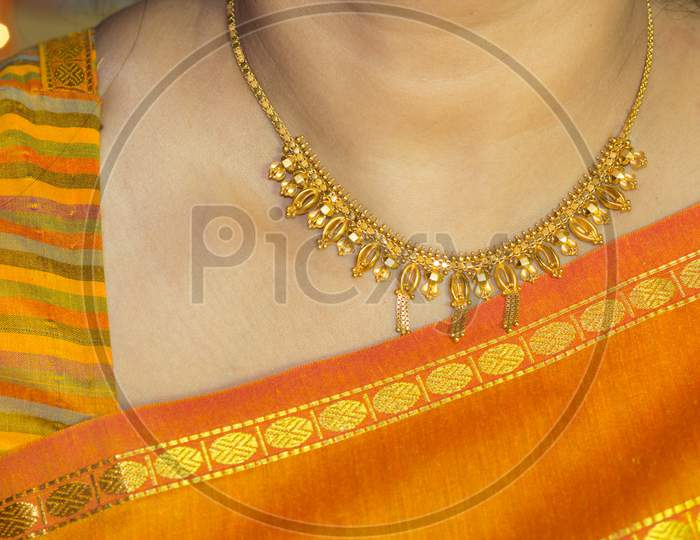 A Beautiful Close up view of a Gold Neck Jewelry worn with the traditional Sari of an Hindu Lady during Diwali festival of Lights in India.