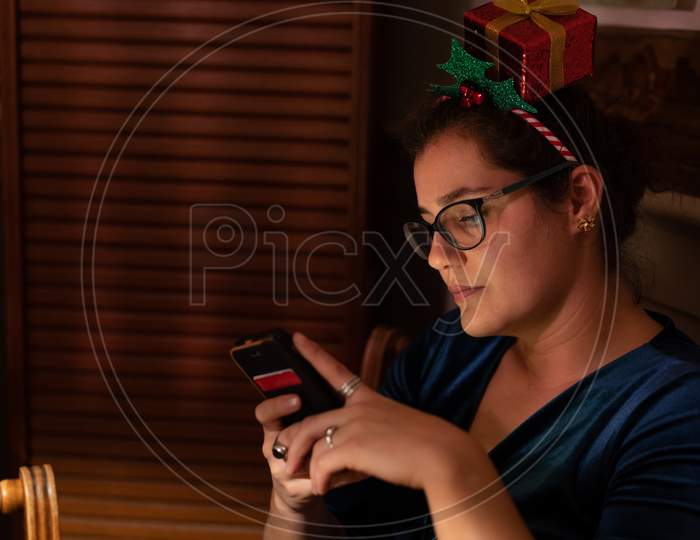 Young Woman Messaging With People On Christmas Eve.