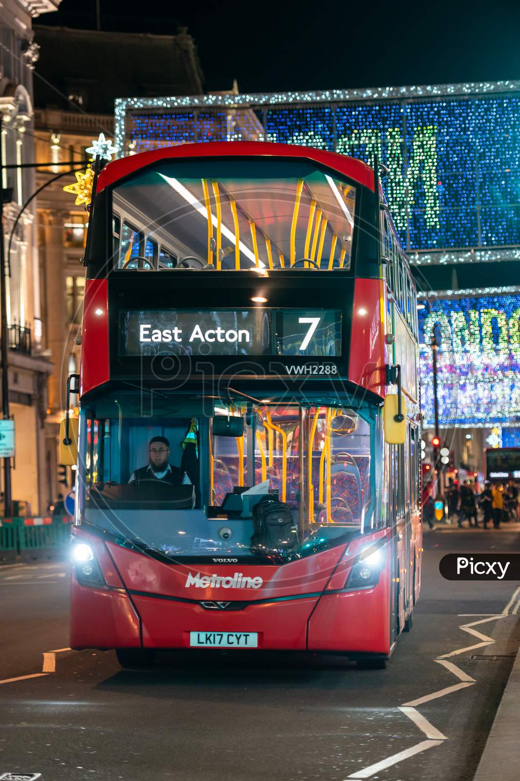 Red London Double Decker Bus With Oxford Street Illuminated Christmas Decorations In The Background