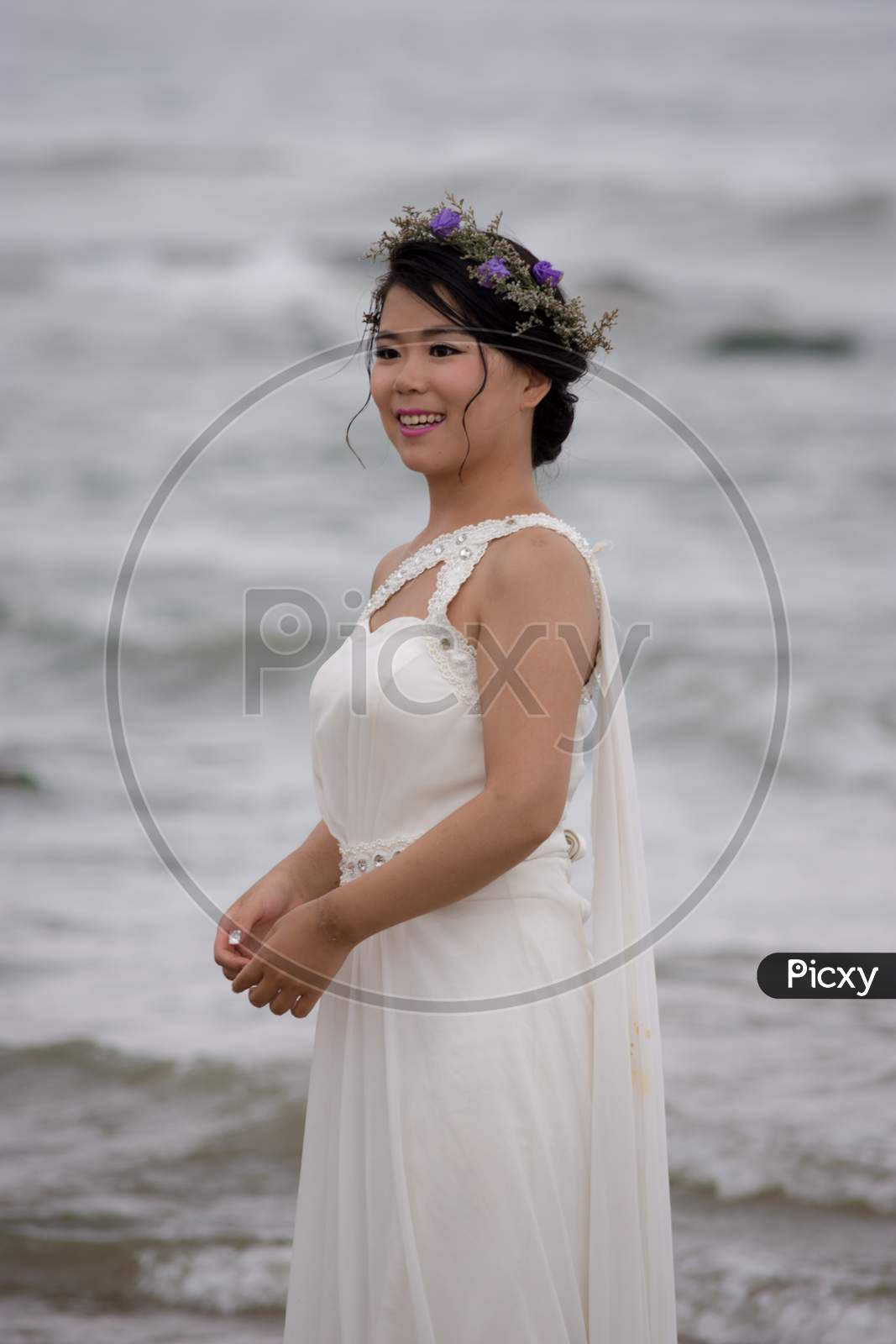 Chinese Bride In A White Wedding Dress Posing At The Beach
