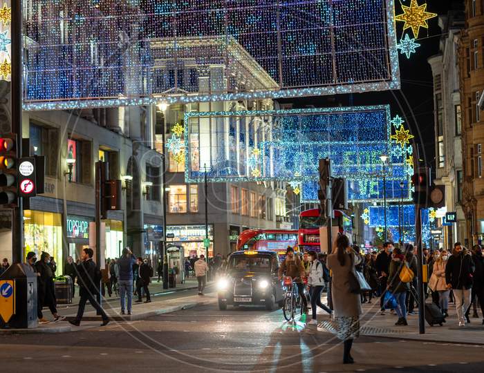 Pedestrians And Traffic Beneath The Oxford Street Christmas Decorations At Night