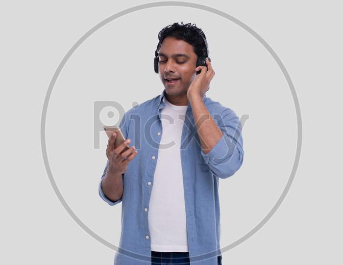 Indian Man Listening To Music From Phone Singing To It. Man Singing To The Music.