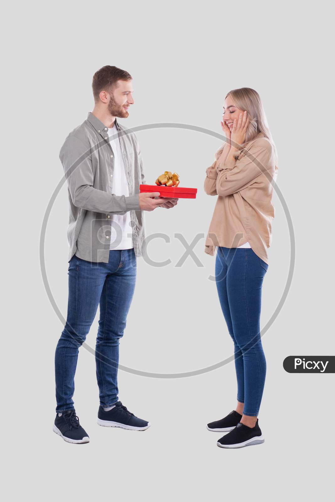Couple Standing Isolated. Woman Suprised By Gift From Man. Man Making A Gift To Girl. Couple Day. Present For Girl