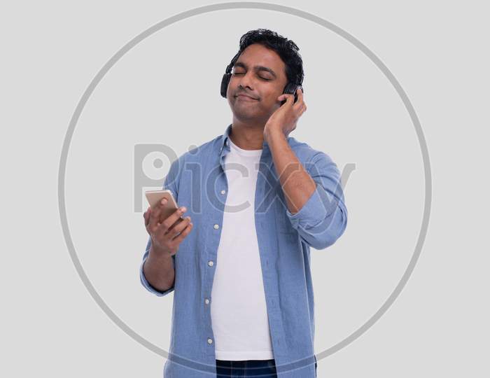Indian Man Listening To Music From Phone Enjoying It Eyes Closed. Man Listening To The Music.