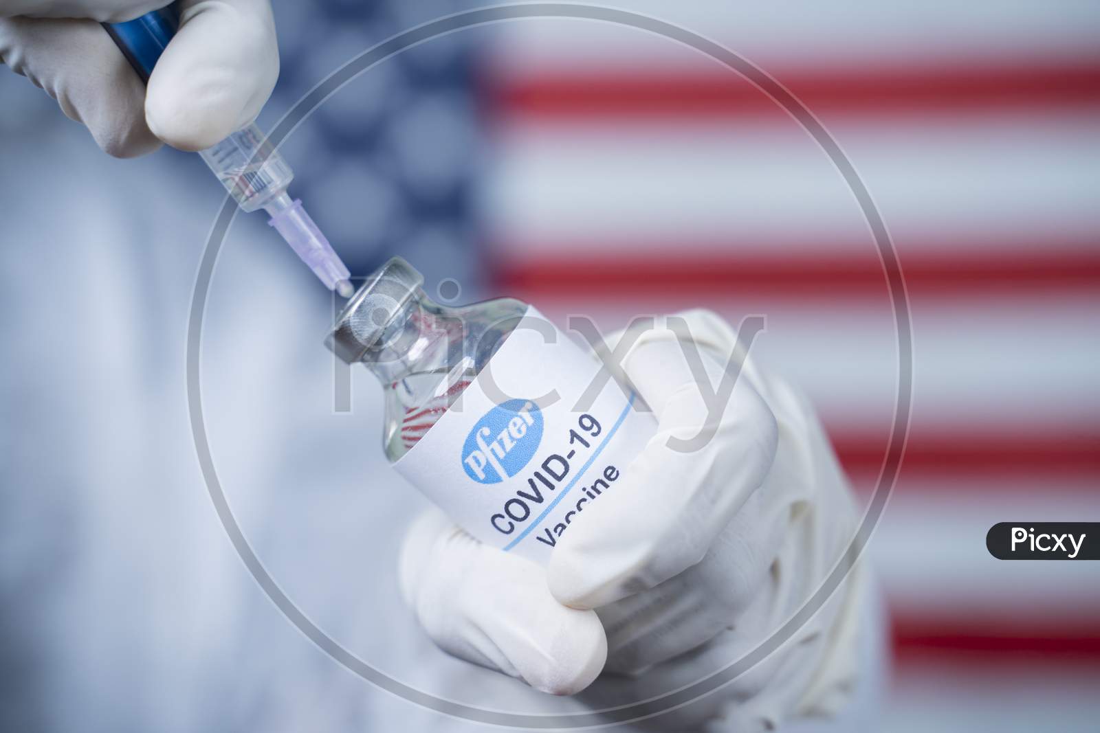 Maski, India - Nov 12,2020 : Doctor Holding Pfizer Biontech Vaccine And Syringe To Protect Against Coronavirus Covid-19 Disease With Us Flag As Background.
