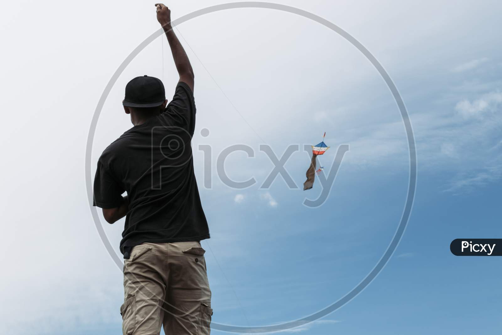Photograph Of A Young Boy Flying A Kite On A River Bank