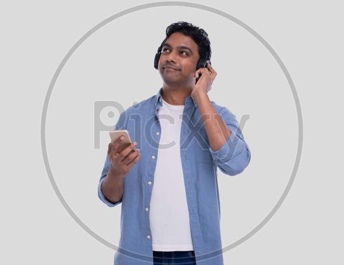 Indian Man Listening To Music From Phone Enjoying It. Man Listening To The Music.