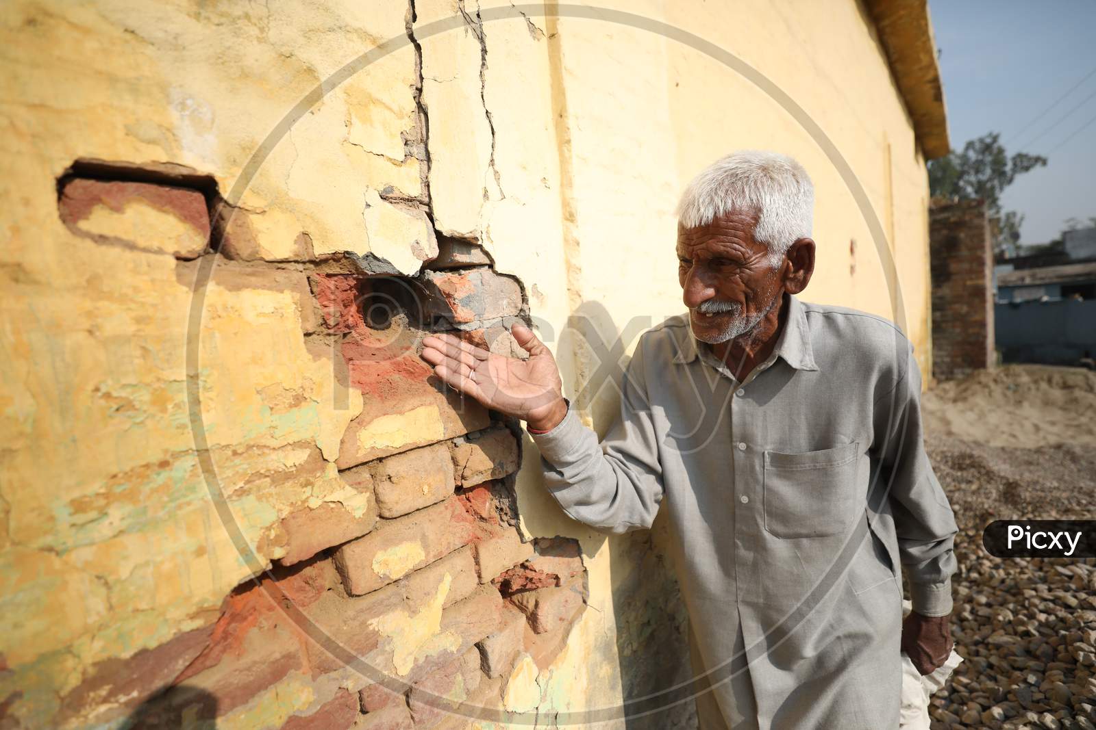 Border villager shows the pockmarked wall of a building damaged by alleged shelling from the Pakistani side of the  border in Manyari village of Kathua about 65 kms from Jammu,11 November,2020.