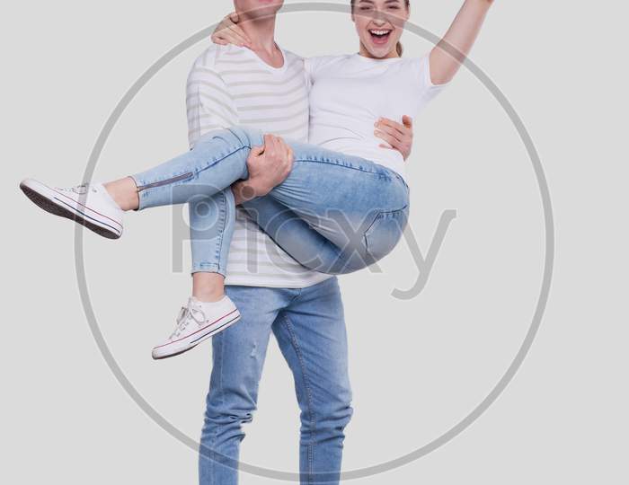 Man Holding Girl In His Arms. Couple Standing Isolated. Lovely Couple Looking To The Camera Girl Is Happy Holding Hand Up. Cute Couple, Family, Friends, Lovers Concept