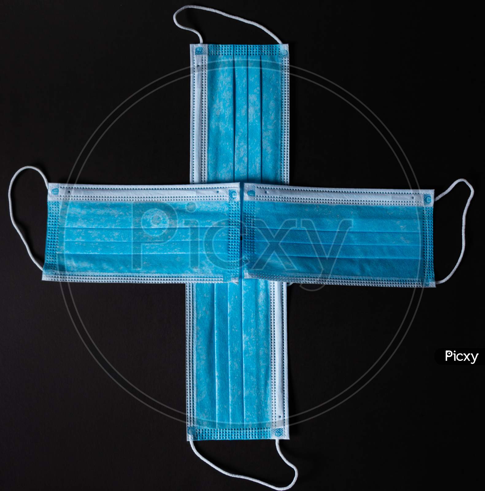 Four Surgical Face Masks Put Together As A Cross In Black Background