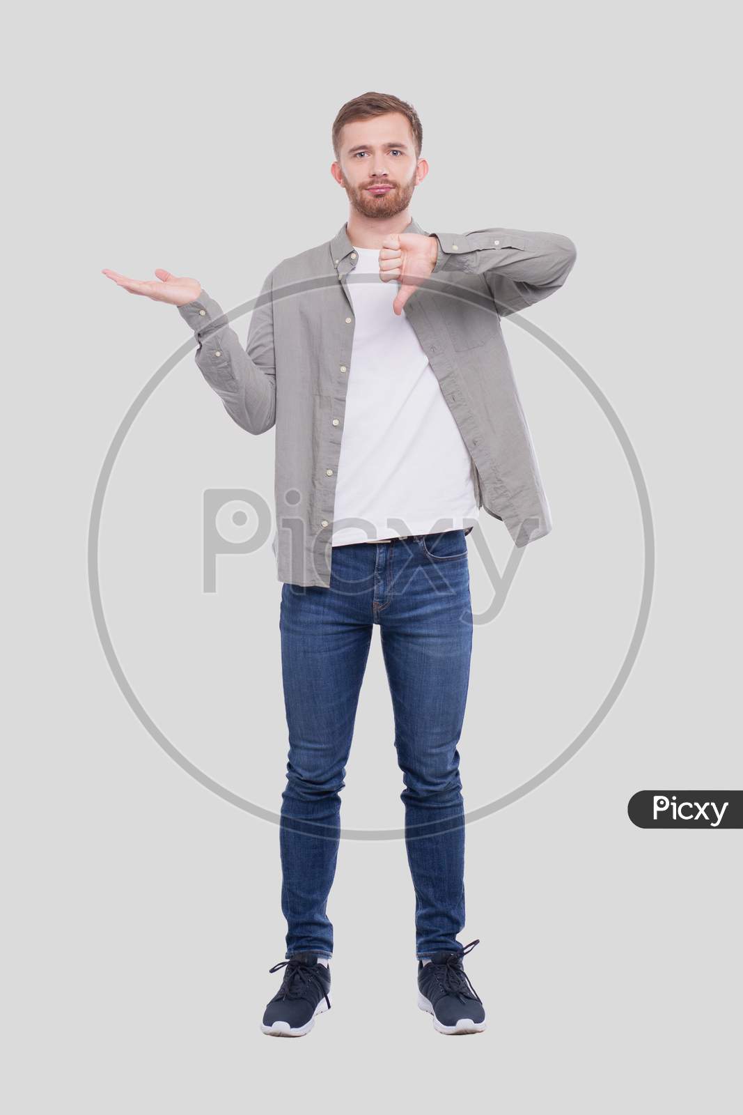 Man Showing Hand To Side And Showing Thumb Down Isolated. Man Full Lenght Standing