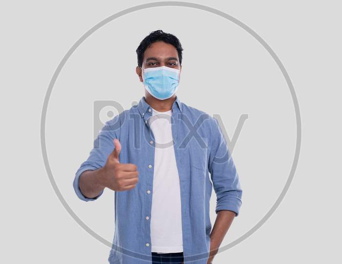 Indian Man Wearing Medical Mask Showing Thumb Up Isolated. Man In Blue Shirt With Medical Mask. Health, Virus, Medical Concept