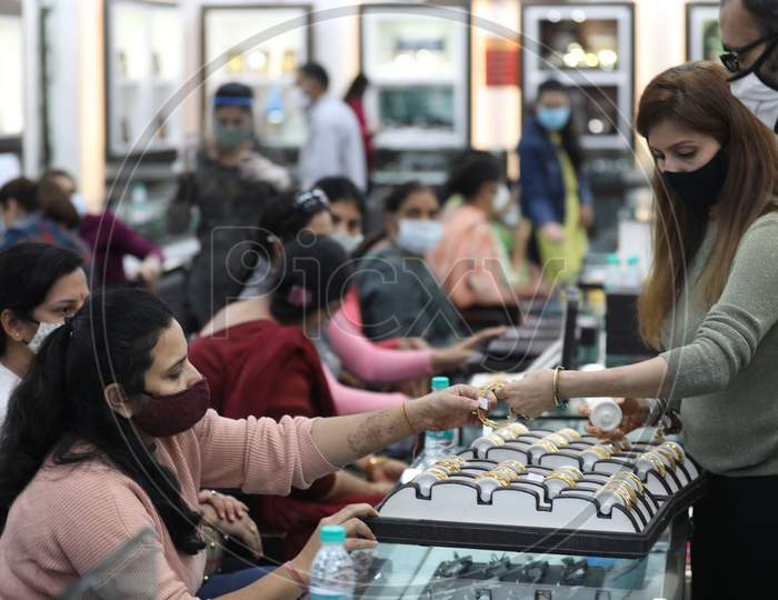 People buy gold ornaments at a jewellery showroom on the auspicious occasion of Dhanteras, in Jammu ,12,November,2020.