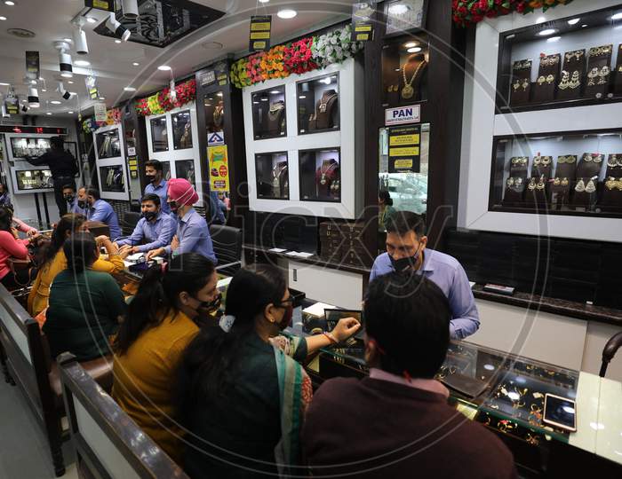 People buy gold ornaments at a jewellery showroom on the auspicious occasion of Dhanteras, in Jammu ,12,November,2020.