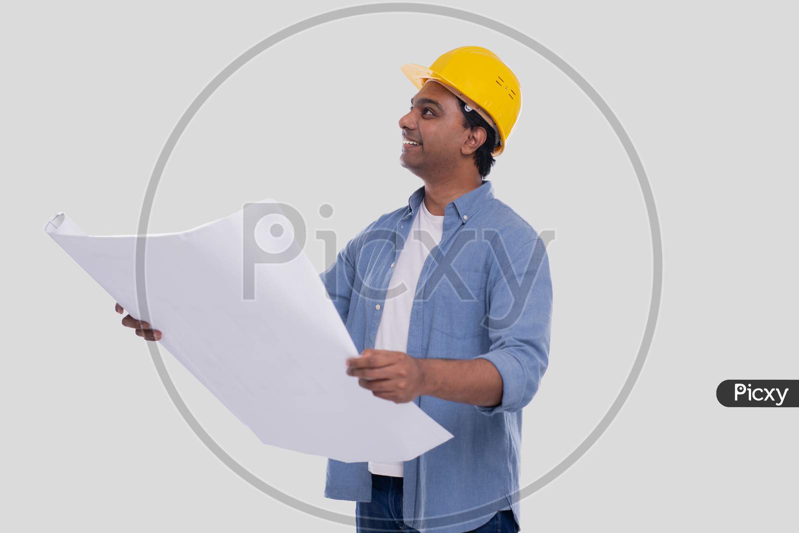 Construction Worker Holding House Plan In Hands Watching Up. Architect Holding Blueprints. Yellow Hard Helmet.
