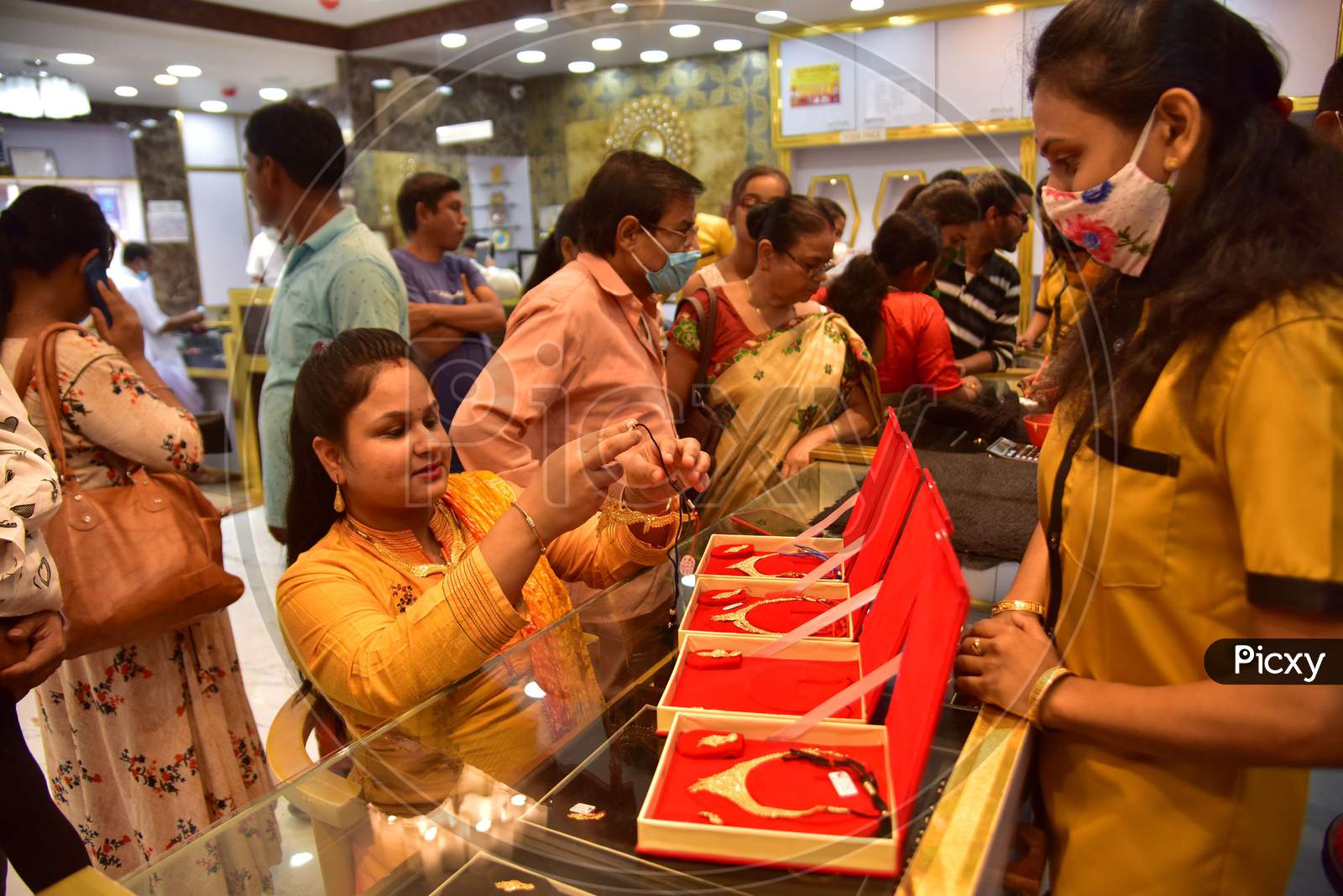 A woman tries a gold ornaments  at a jewellery showroom during Dhanteras in Nagaon district, in the northeastern state of Assam on Nov 12,2020