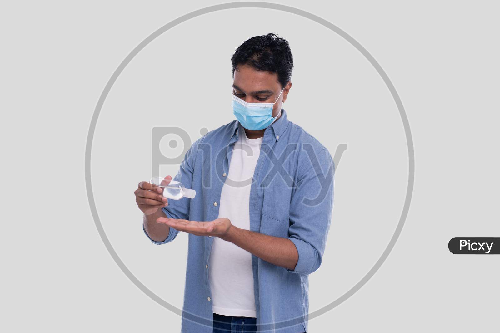 Indian Man Wearing Medical Mask Using Hand Sanitizer. Man Using Hands Antiseptic