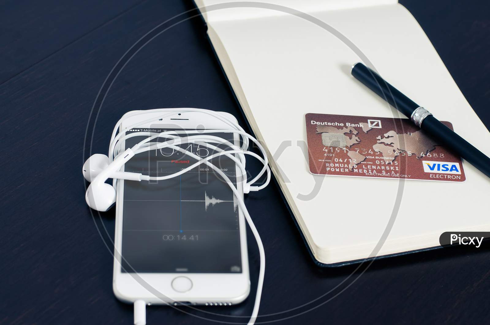 iPhone On Desk With Earphone , Credit Card & Pen