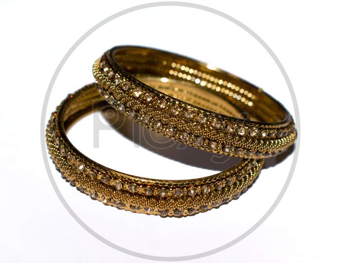 Indian traditional gold coated wedding Bangles isolated on white.