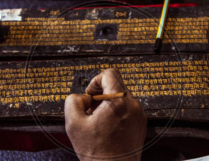 Ranjhana lipi being written with gold.