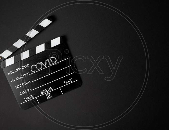 Movie Clapperboard During The Second Wave Of The Coronavirus Pandemic On A Black Background. Covid Concept.