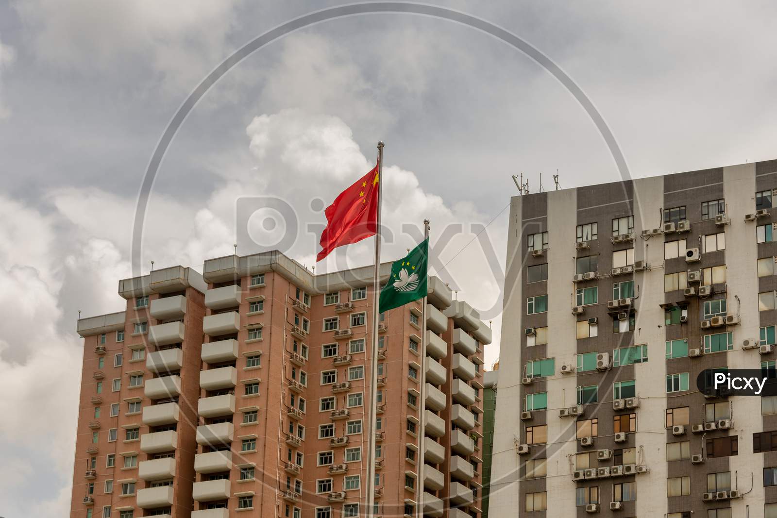 Flags Of China And Sar Macau In Front Of Residential Buildings In Macau, China