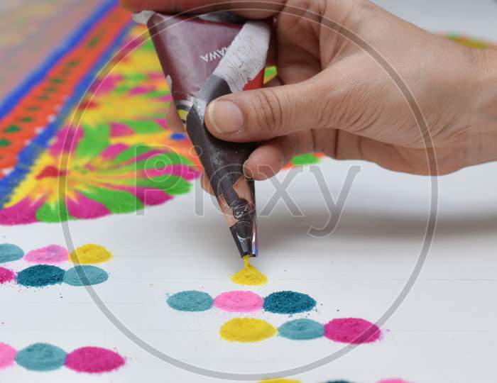 Woman Hand Making Rangoli Designs With Paper Cone Using Different Rangoli Colors