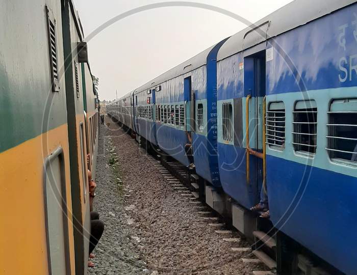 Indian Railways Train departing from station at slow pace, while crossing another train running parallel to it in opposite direction,