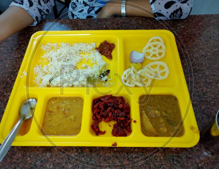 yellow plate of food with variety of food items. Serving trays with delicious food on table . concept of school lunch