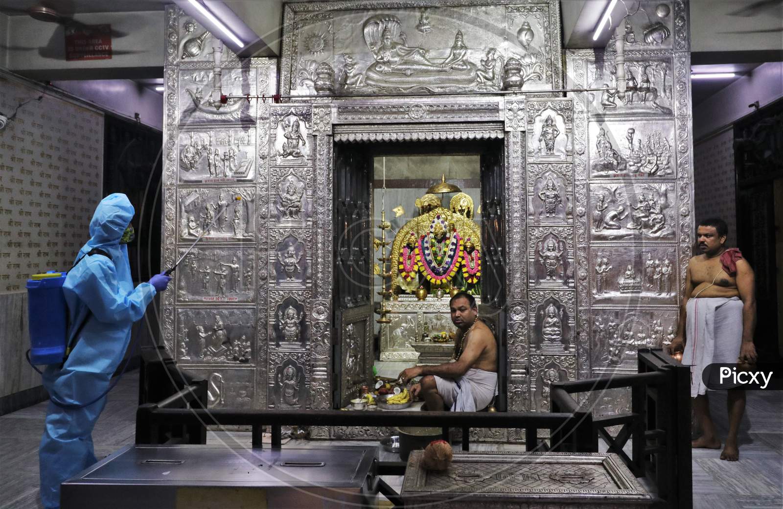 A man in personal protective equipment (PPE) sanitizes a temple before they reopen for the public amid the spread of the coronavirus disease (COVID-19) in Mumbai, India on November 15, 2020.