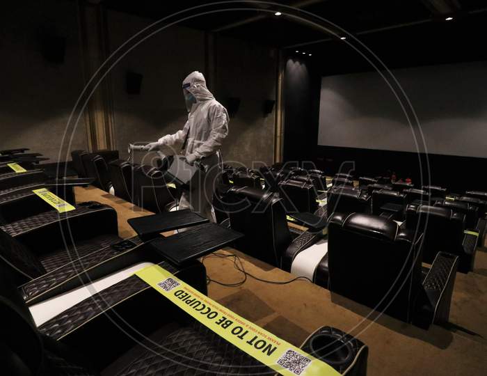 A man in personal protective equipment (PPE) sanitizes a cinema hall before a movie amid the spread of the coronavirus disease (COVID-19) in Mumbai, India on November 15, 2020.