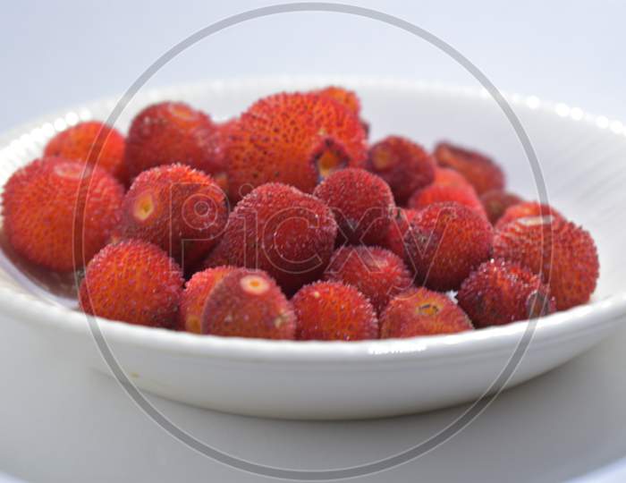 red wild fruits in white plate
