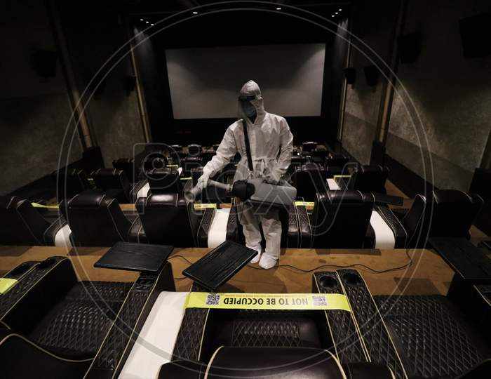 A man in personal protective equipment (PPE) sanitizes a cinema hall before a movie amid the spread of the coronavirus disease (COVID-19) in Mumbai, India on November 15, 2020.