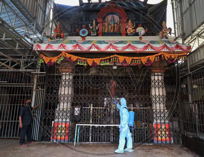 A man in personal protective equipment (PPE) sanitizes a temple before they reopen for the public amid the spread of the coronavirus disease (COVID-19) in Mumbai, India on November 15, 2020.