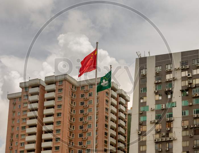 Flags Of China And Sar Macau In Front Of Residential Buildings In Macau, China