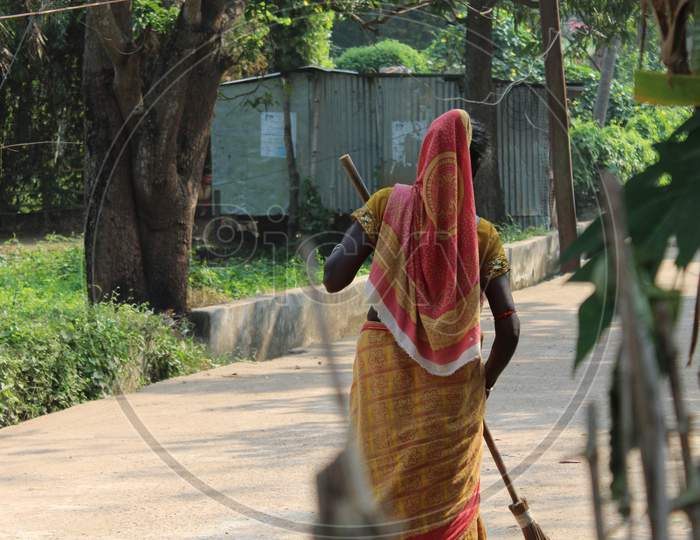 Women Sweeper Clean The Road With Wearing Colorful Saree  And Hold On The Scrub Brush.