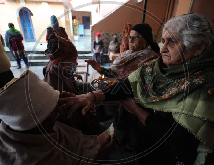 Old age Home Women mark a tilaka on an old man forehead, during the Bhai Dooj festival, in Jammu,16 November.2020.