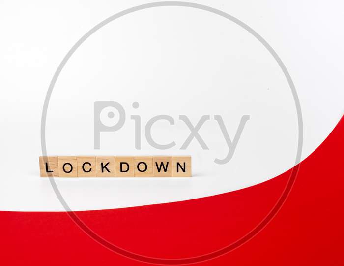 Wooden Letters On A White And Red Background Forming The Word “Lockdown”. Second Wave During Coronavirus Pandemic Concept.