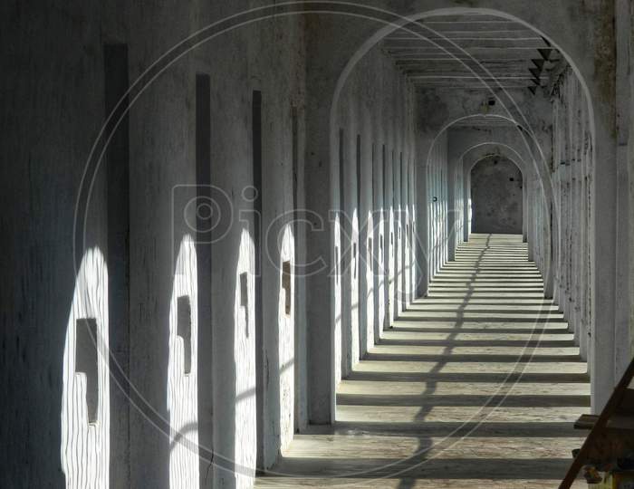 Long corridor in jail with sunlight bashing on the doors