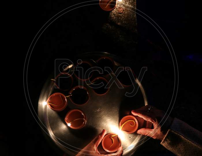Man and woman lighting diyas on diwali