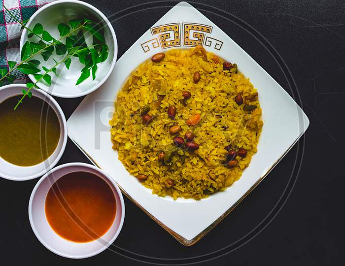 Poha on a plate with different chutneys