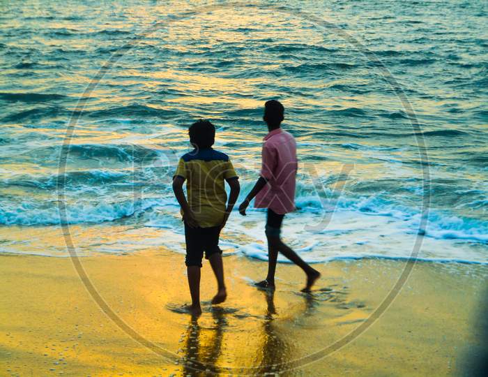 Two brother gazing ath sun set on a beach