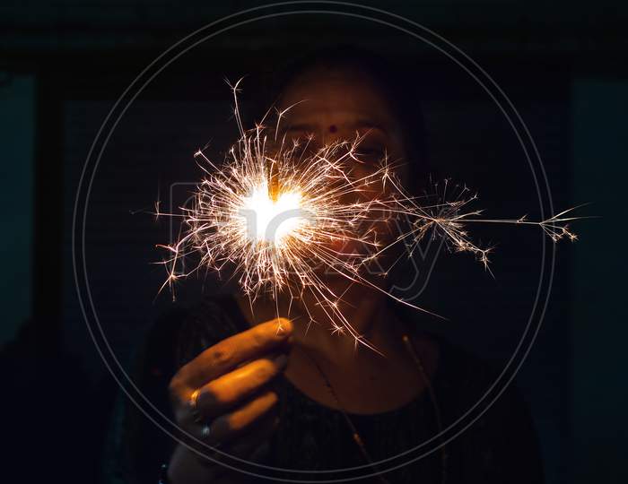Woman / person holding sparkler in hand
