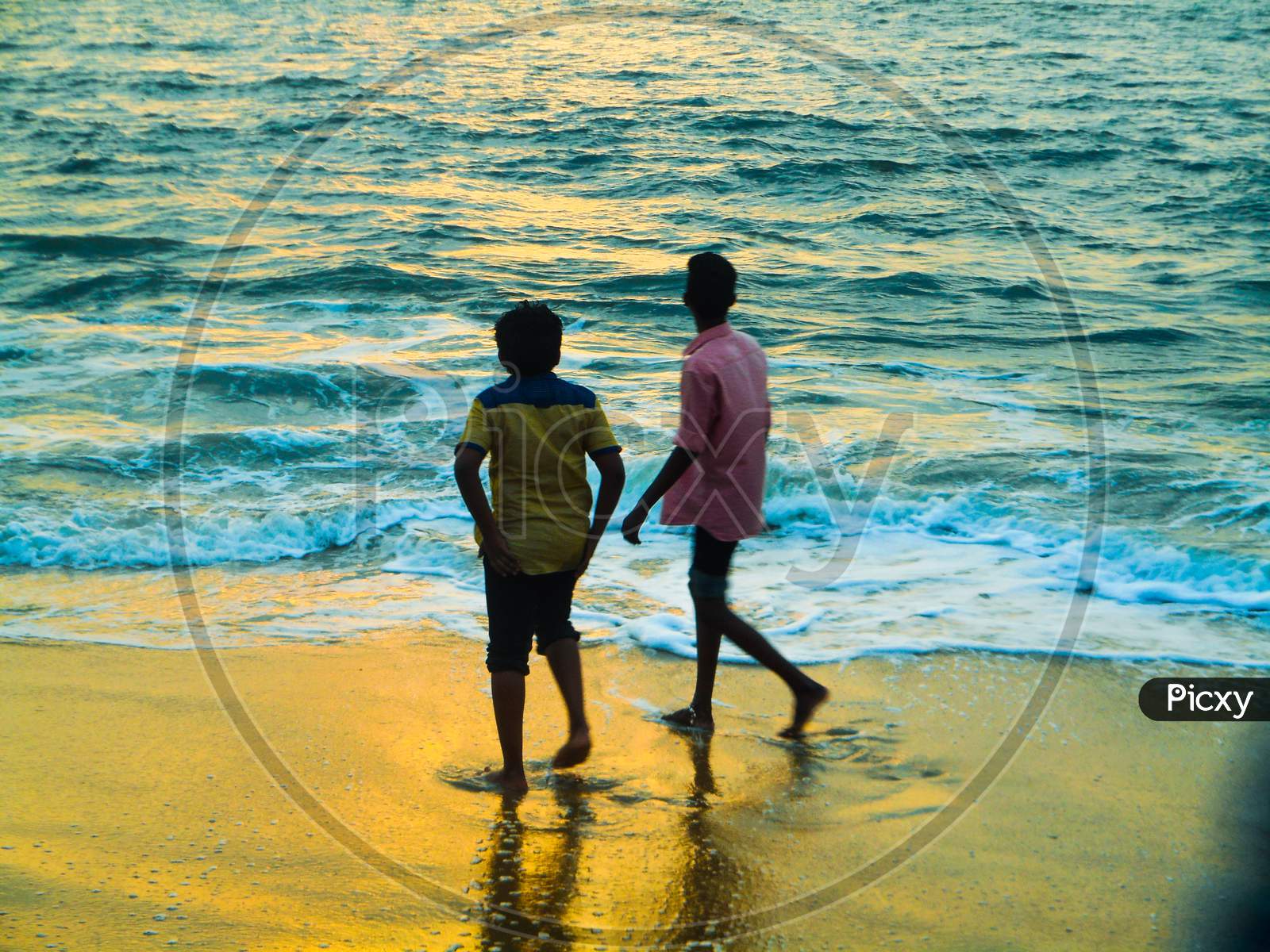 Two brother gazing ath sun set on a beach
