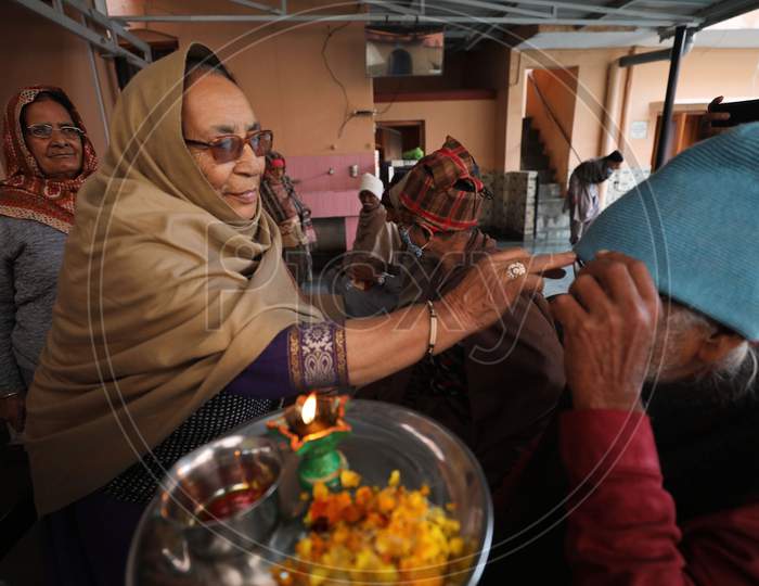 Old age Home Woman marks a tilaka on an old man's forehead, during the Bhai Dooj festival, in Jammu,16 November.2020.