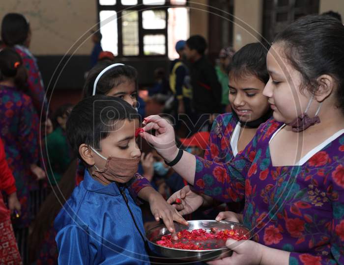 Orphan girls mark a tilaka on a boy's forehead, during the Bhai Dooj festival, at an orphanage in Jammu ,16 November.2020.