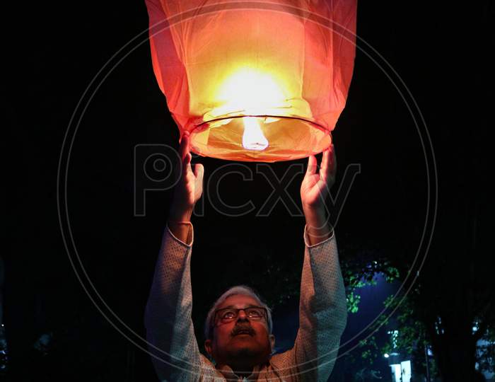 person / Man releasing paper floating /sky lantern on diwali